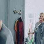 Kobieta w sklepie przymierza kurtkę, oglądając się w lustrze